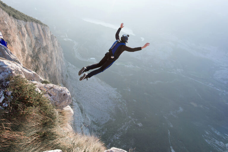 BASE jumping — skoczek tuż po odbiciu od skalnego urwiska.